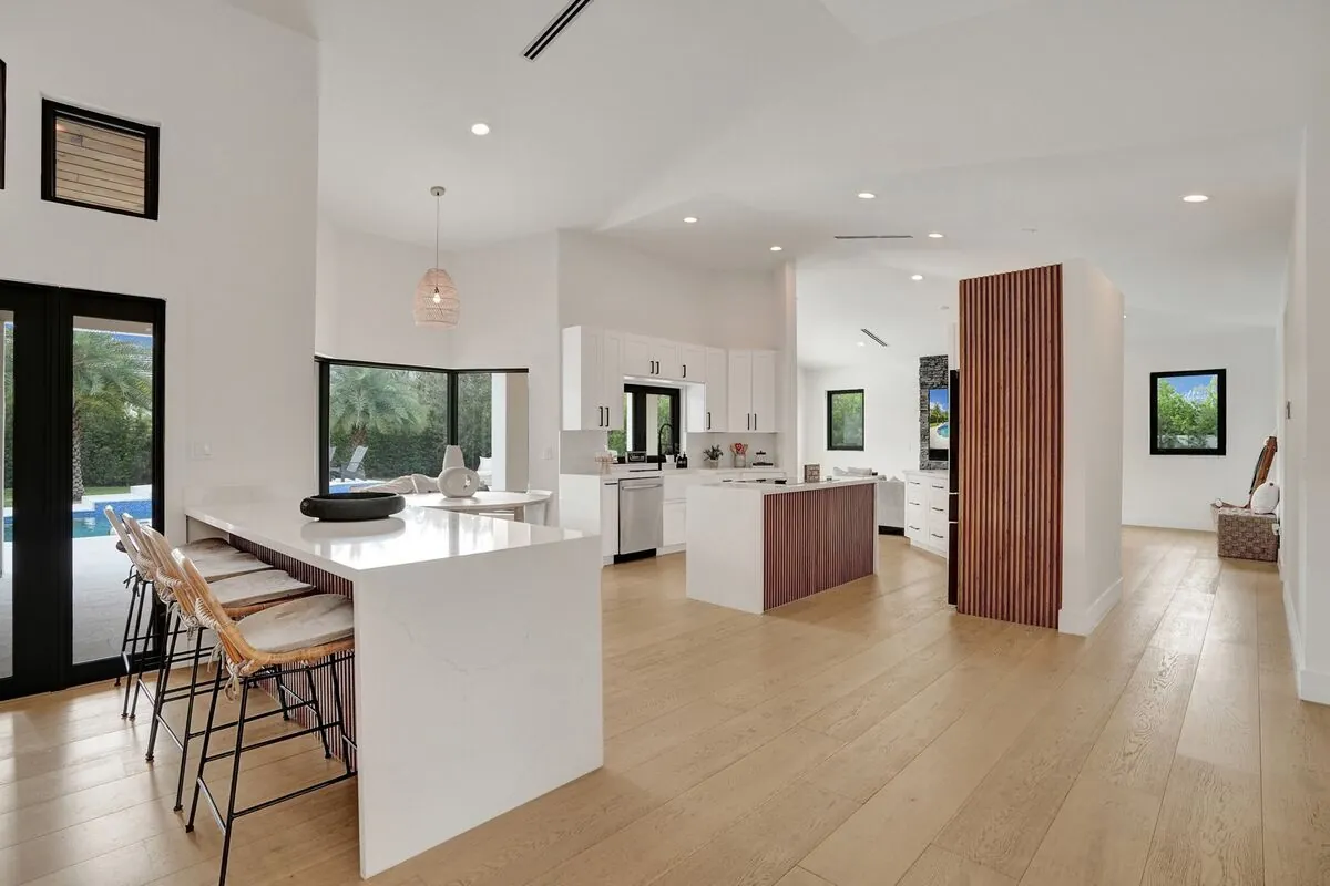 Light oak floors running through an open-plan kitchen and dining area